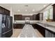 Modern kitchen featuring stainless steel appliances, granite countertops, and dark wood cabinets at 168 Springhouse St, Las Vegas, NV 89148