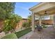 Relaxing outdoor patio with covered area, chairs, and manicured landscaping at 168 Springhouse St, Las Vegas, NV 89148