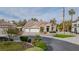 Charming single-story home with a three-car garage, desert landscaping, and a welcoming blue door at 1720 Sand Storm Ct, Henderson, NV 89074