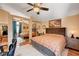 Comfortable bedroom featuring mirrored closet doors and ceiling fan with light fixture at 1721 Derbyshire Dr, Las Vegas, NV 89117
