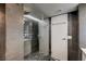 Contemporary bathroom with a glass-enclosed shower, gray tile walls, and stone flooring at 205 E Harmon Ave # 1010, Las Vegas, NV 89169