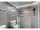 Modern bathroom featuring sleek gray tiles, frameless glass shower, and a built-in niche for storage at 205 E Harmon Ave # 1010, Las Vegas, NV 89169