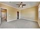Spacious carpeted bedroom featuring a ceiling fan, neutral walls, and natural light from the windows at 21 Via Mantova # 3, Henderson, NV 89011
