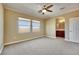 Spacious bedroom with neutral carpet, ceiling fan, and view of mountains through two large windows at 21 Via Mantova # 3, Henderson, NV 89011