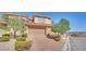 Two-story home with tile roof, desert landscaping, and a brick-paver driveway at 21 Via Mantova # 3, Henderson, NV 89011