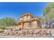 Beautiful home exterior showing well-manicured landscaping and a retaining wall of decorative boulders at 21 Via Mantova # 3, Henderson, NV 89011