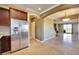 Open-concept layout connecting the kitchen to the living area, with stainless steel appliances and travertine flooring at 21 Via Mantova # 3, Henderson, NV 89011