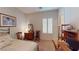 Cozy bedroom with light-colored walls, a window, and a wood-framed picture at 2309 Aztec Ruin Way, Henderson, NV 89044