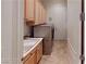 Well-equipped laundry room with a sink, cabinets, and a modern washer and dryer at 2309 Aztec Ruin Way, Henderson, NV 89044