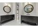Modern bathroom featuring dual sinks, elegant mirrors, and marble flooring at 26 Moraine Dr, Henderson, NV 89052
