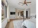 Bright bedroom featuring hardwood floors, a ceiling fan, a tv, and a view of the patio at 26 Moraine Dr, Henderson, NV 89052