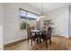 Well-lit dining area featuring a dark wood table, hardwood floors, and a large window with backyard view at 26 Moraine Dr, Henderson, NV 89052