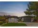 Charming single-story home boasts mature landscaping, gray stucco, and a two-car garage at 26 Moraine Dr, Henderson, NV 89052