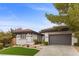 Charming single-story home boasts mature landscaping, gray stucco, and a two-car garage at 26 Moraine Dr, Henderson, NV 89052