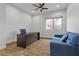 Bright office space with a dark desk, blue sofa, hardwood floors, a ceiling fan, and natural lighting at 26 Moraine Dr, Henderson, NV 89052