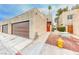 Exterior view of a stucco home with a garage, side entrance, and a yellow fire hydrant nearby at 2632 Matogroso Ln, Las Vegas, NV 89121