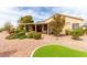 Landscaped backyard featuring artificial turf, mature trees, rock ground cover, and a covered patio with solar panels at 2971 Fort Matanzas Ter, Henderson, NV 89052