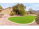 Beautiful backyard with an artificial grass area, desert landscaping, and mature trees at 2971 Fort Matanzas Ter, Henderson, NV 89052