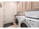 Bright laundry room featuring front-loading washer and dryer with upper cabinets for ample storage at 2971 Fort Matanzas Ter, Henderson, NV 89052