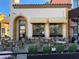 Inviting outdoor cafe seating area with yellow striped awnings and stylish chairs and tables at 30 Strada Di Villaggio # 439, Henderson, NV 89011