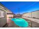 Backyard pool with manicured landscaping and night lighting, enveloped by a crisp white privacy wall at 3517 Spencer St, Las Vegas, NV 89169