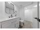 A modern bathroom with a white vanity, matte black hardware, a large mirror, and wood look flooring at 3597 Arville St # 201B, Las Vegas, NV 89103