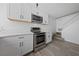 Contemporary kitchen boasts stainless steel appliances, white cabinetry, marble countertops, and wood look flooring at 3597 Arville St # 201B, Las Vegas, NV 89103