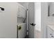 A compact laundry area featuring a stacked washer and dryer in a hallway adjacent to a bathroom at 3597 Arville St # 201B, Las Vegas, NV 89103