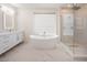 Bright bathroom featuring a modern shower, a soaking tub, and a sleek vanity with drawers and cabinets at 386 Cactus River Ct, Henderson, NV 89074