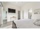 Spacious bedroom featuring a large TV, light floors, and doorway access to ensuite bathroom at 386 Cactus River Ct, Henderson, NV 89052