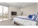 A bright bedroom featuring a sliding glass door to a balcony and a TV on a wooden table at 386 Cactus River Ct, Henderson, NV 89052
