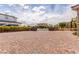 Long brick driveway leading to a home with manicured landscaping and a circular driveway in the distance at 386 Cactus River Ct, Henderson, NV 89052