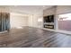 Spacious living room with electric fireplace, mounted TV, and wine storage, illuminated by natural light at 386 Cactus River Ct, Henderson, NV 89074