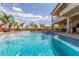 Inviting backyard oasis with a sparkling pool and lush landscaping with palm trees at 386 Cactus River Ct, Henderson, NV 89052