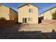 View of the house's backyard with a dirt lot, brick fence, and sliding glass door entry at 41 Rosa Rosales Ct, North Las Vegas, NV 89031