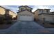 Beige two-story home featuring an attached two-car garage and low maintenance landscaping at 41 Rosa Rosales Ct, North Las Vegas, NV 89031