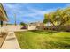 Large grassy backyard with storage shed and mature trees, perfect for outdoor activities at 4795 W Maulding Ave, Las Vegas, NV 89139