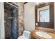 Bathroom featuring decorative tile shower with marble countertops and wood-framed mirror at 4795 W Maulding Ave, Las Vegas, NV 89139