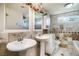 Bathroom with double pedestal sinks, decorative tile, and well-lit mirrors at 4795 W Maulding Ave, Las Vegas, NV 89139