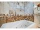 A luxurious bathtub with jacuzzi jets surrounded by designer tiles and mosaic accents at 4795 W Maulding Ave, Las Vegas, NV 89139