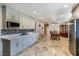 Open kitchen with gray cabinets, stainless appliances, and travertine flooring at 4795 W Maulding Ave, Las Vegas, NV 89139