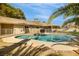 An in-ground pool in a fenced backyard with landscaping and mature trees reflecting in the water at 4795 W Maulding Ave, Las Vegas, NV 89139