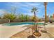 Outdoor pool area featuring palm trees, patio seating, and a well-maintained pool under a blue sky at 4795 W Maulding Ave, Las Vegas, NV 89139