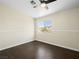 Neutral bedroom featuring hardwood floors, a window with views, and a ceiling fan at 5330 E Charleston Blvd # 116, Las Vegas, NV 89142