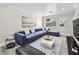 Living room featuring a large blue couch, decorative paintings, and a view from the window at 5330 E Charleston Blvd # 116, Las Vegas, NV 89142