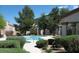 Community pool with a lounging area, lush landscaping and a wrought iron fence at 5650 E Sahara Ave # 2041, Las Vegas, NV 89142