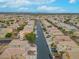 Vast aerial view showcasing an orderly neighborhood with uniform homes, tree-lined streets, and scenic mountain backdrop at 6429 Pronghorn Ridge Ave, Las Vegas, NV 89122
