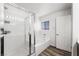 Bathroom featuring glass enclosed shower and soaking tub with white tile and wood floor at 6429 Pronghorn Ridge Ave, Las Vegas, NV 89122