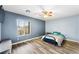 Cozy bedroom with wood-look floors, a ceiling fan, and a window offering natural light at 6429 Pronghorn Ridge Ave, Las Vegas, NV 89122