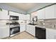 Well lit kitchen with stainless steel appliances, white cabinetry, and tiled floors at 6429 Pronghorn Ridge Ave, Las Vegas, NV 89122